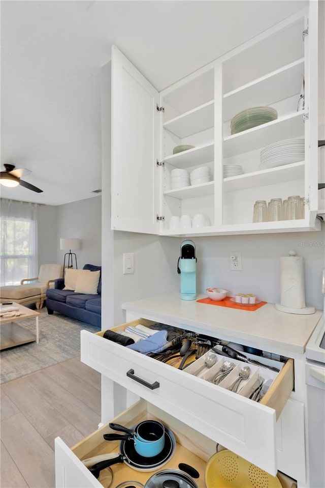 kitchen featuring a ceiling fan, light wood-style flooring, light countertops, white cabinetry, and open shelves