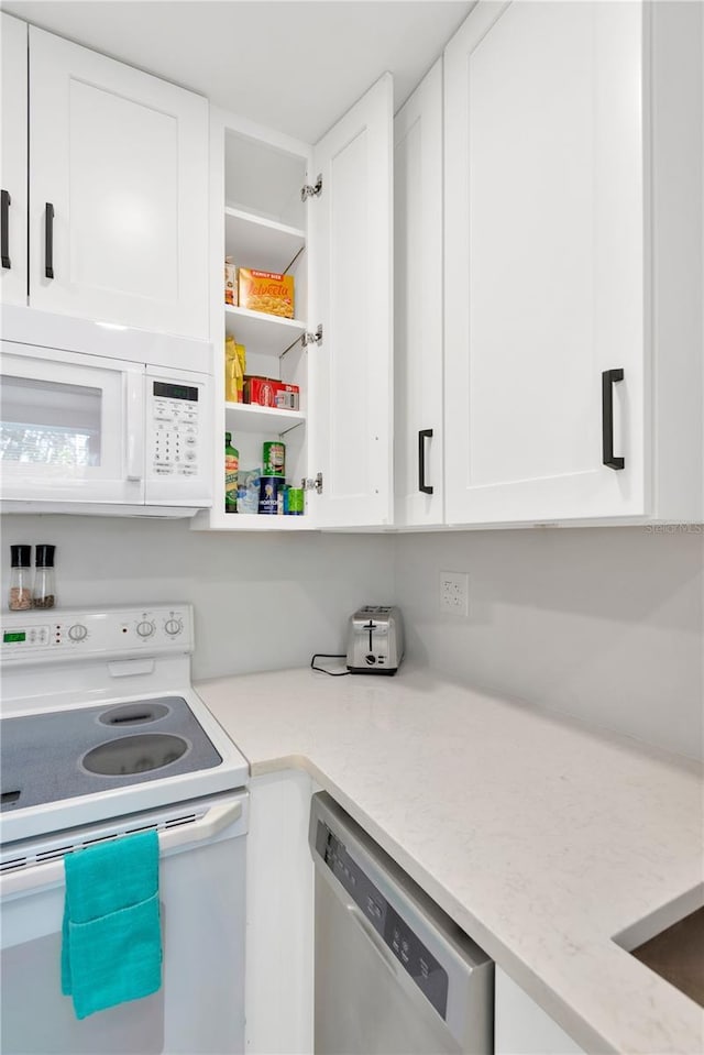 kitchen featuring light stone counters, white appliances, white cabinetry, and open shelves