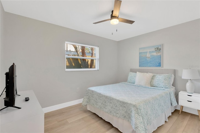 bedroom featuring light wood finished floors, baseboards, and a ceiling fan