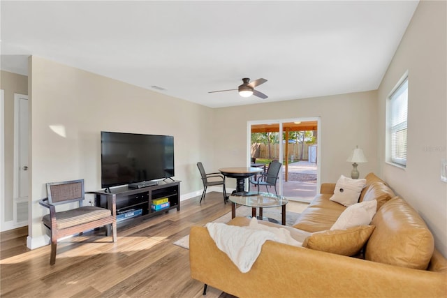 living area featuring ceiling fan, wood finished floors, visible vents, and baseboards