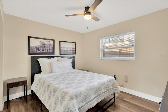 bedroom with wood finished floors, a ceiling fan, and baseboards