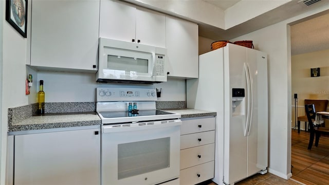 1320 Bottlebrush Dr, Bradenton, FL 34208 - kitchen featuring white appliances, white cabinets, and tile patterned floors