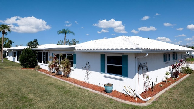 1320 Bottlebrush Dr, Bradenton, FL 34208 - view of side of property featuring stucco siding, a yard, and a tiled roof