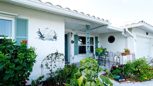 1320 Bottlebrush Dr, Bradenton, FL 34208 - doorway to property with stucco siding, an attached garage, and a porch