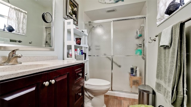 1320 Bottlebrush Dr, Bradenton, FL 34208 - full bathroom with vanity, toilet, a shower stall, and wood finished floors
