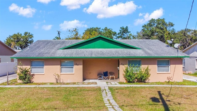 single story home with a front lawn, a shingled roof, fence, and stucco siding