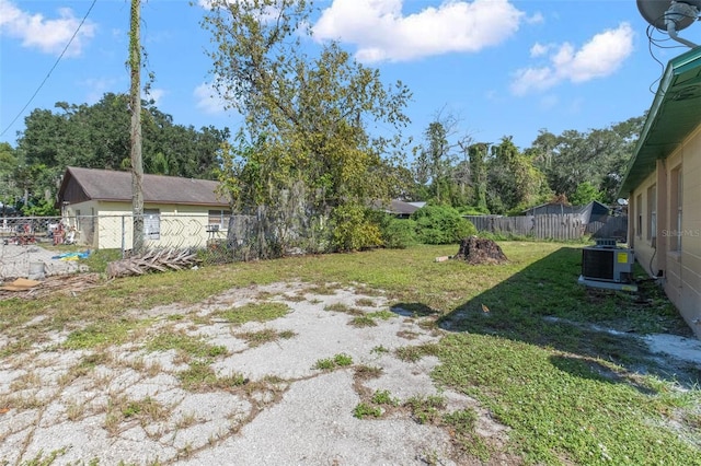 view of yard with a fenced backyard and central AC