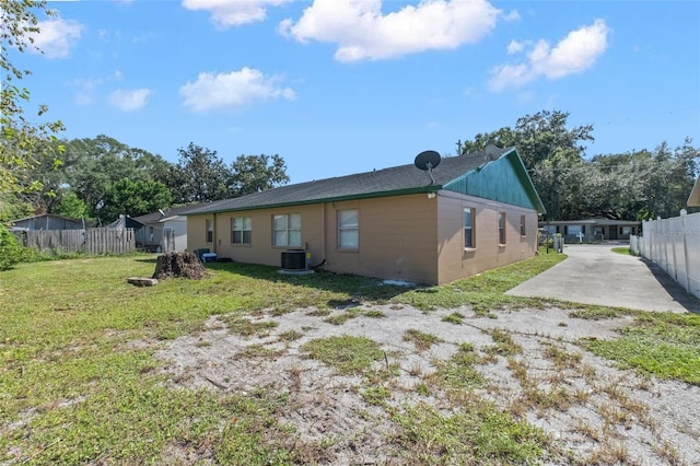 rear view of house with fence and a lawn