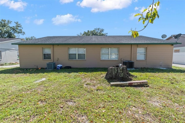 back of property featuring cooling unit and a lawn