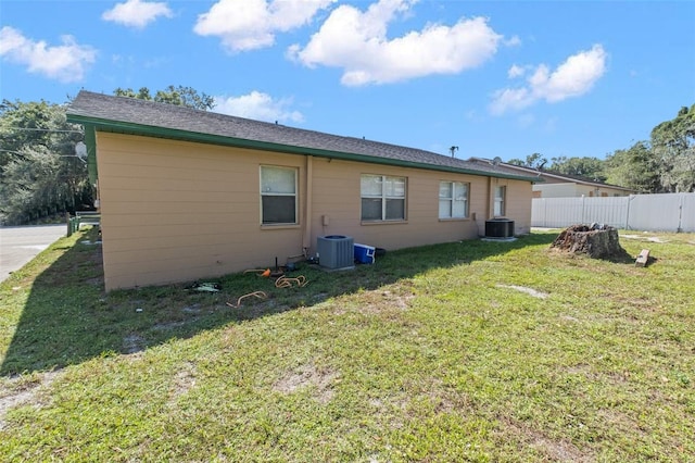 back of house with fence, cooling unit, and a yard