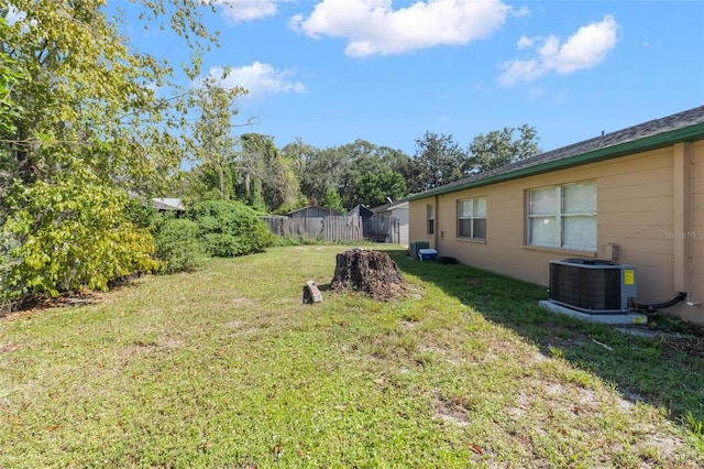 view of yard with fence and central AC