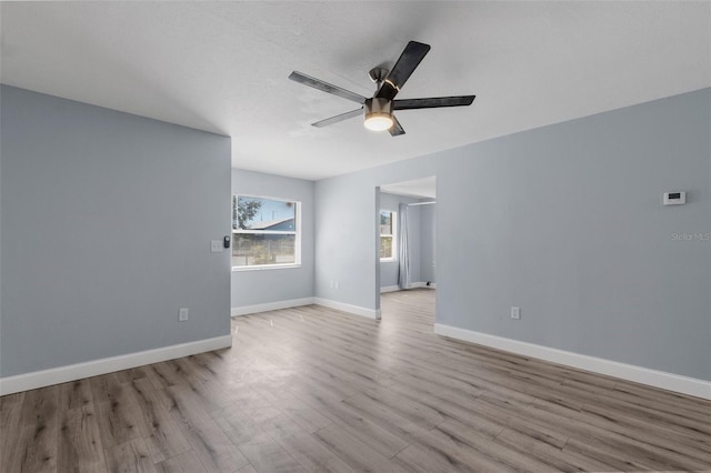 spare room featuring ceiling fan, wood finished floors, and baseboards