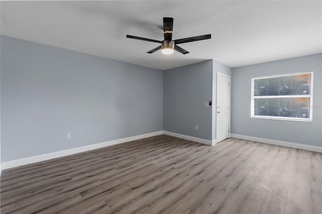 spare room with a ceiling fan, baseboards, and wood finished floors