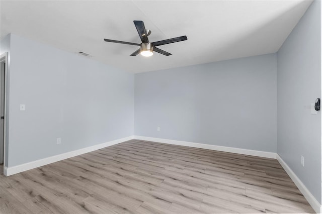 empty room featuring visible vents, ceiling fan, baseboards, and wood finished floors