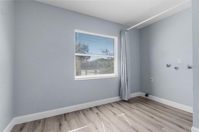 spare room featuring light wood-style floors and baseboards