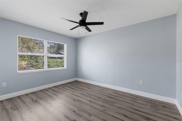 spare room with ceiling fan, baseboards, and wood finished floors