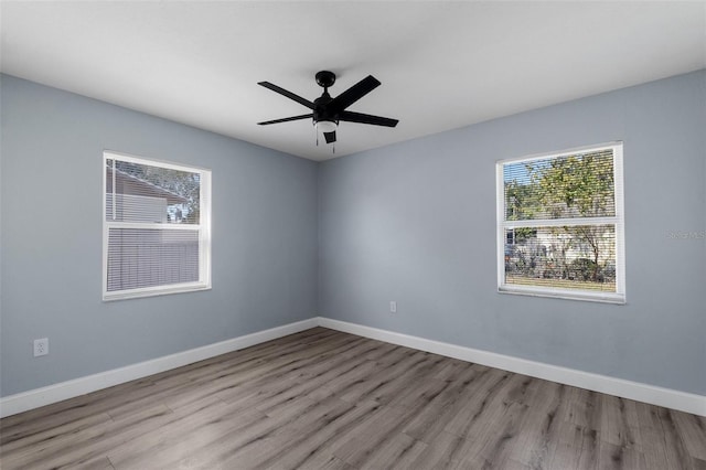 spare room with ceiling fan, baseboards, and wood finished floors