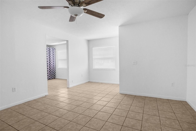 spare room featuring a ceiling fan, tile patterned flooring, and baseboards