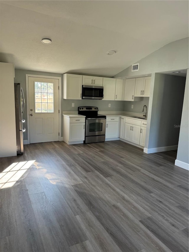 kitchen featuring lofted ceiling, stainless steel appliances, visible vents, and white cabinets