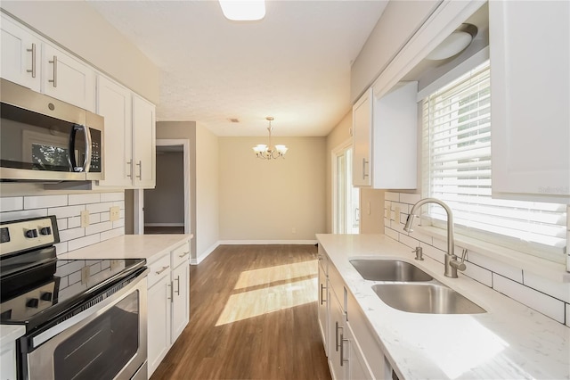 kitchen with dark wood-style flooring, white cabinetry, stainless steel appliances, and a sink