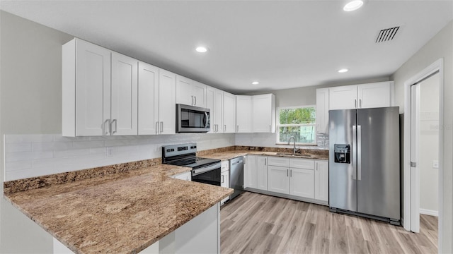 kitchen featuring stainless steel appliances, white cabinets, visible vents, and a sink