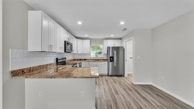 kitchen featuring stainless steel appliances, stone counters, visible vents, and decorative backsplash