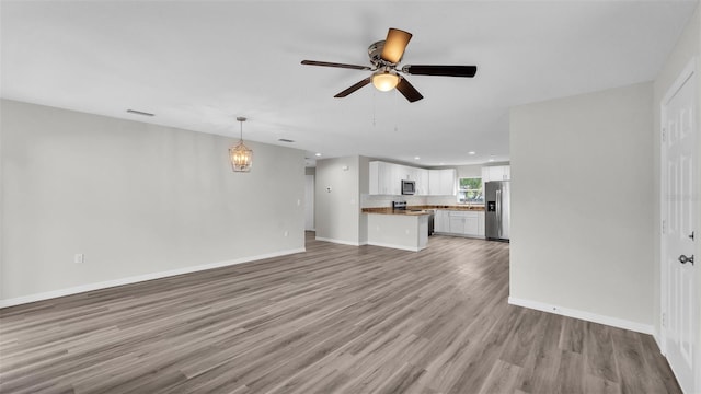 unfurnished living room with a ceiling fan, baseboards, wood finished floors, and recessed lighting