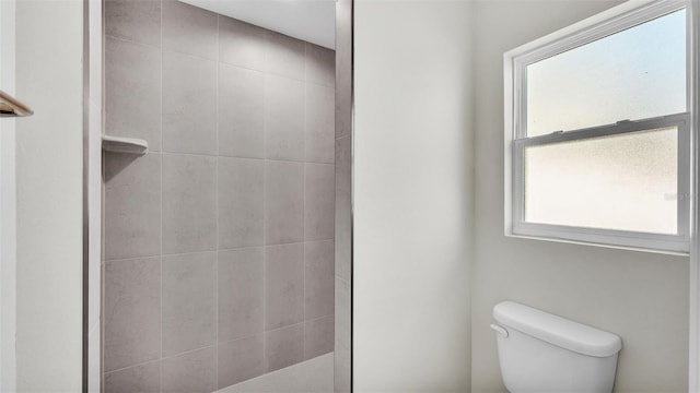 bathroom featuring toilet and a tile shower