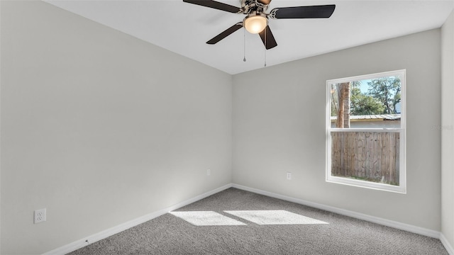 carpeted empty room featuring ceiling fan and baseboards