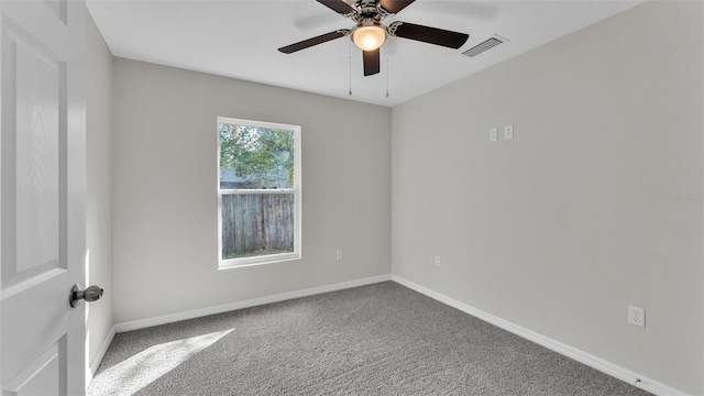 carpeted empty room featuring a ceiling fan, visible vents, and baseboards