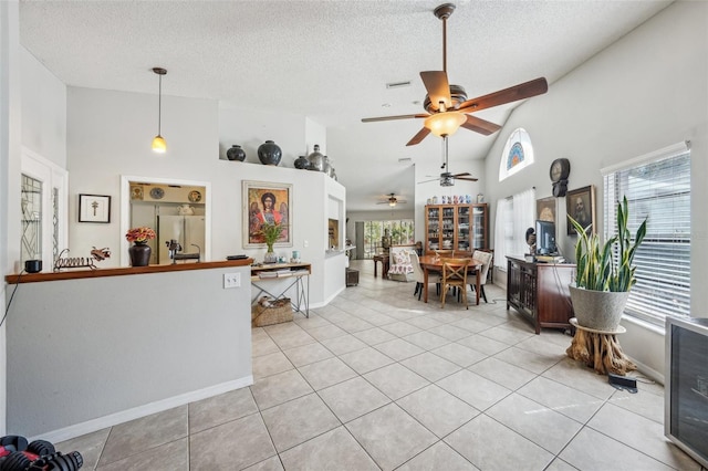 interior space with light tile patterned floors, beverage cooler, freestanding refrigerator, and a healthy amount of sunlight