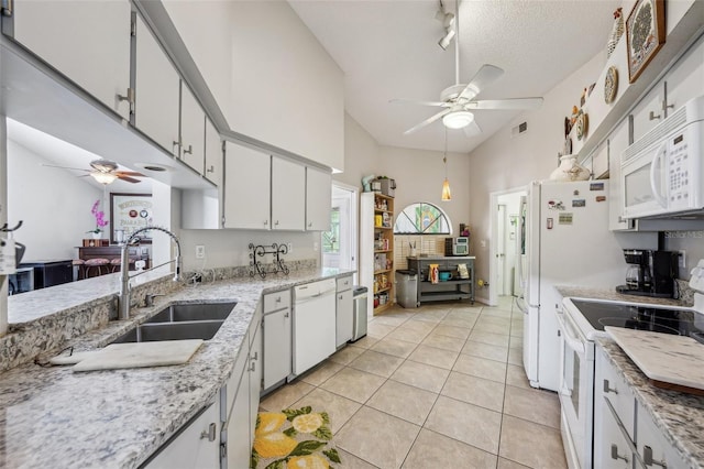 kitchen with light tile patterned floors, white appliances, a sink, a ceiling fan, and white cabinets