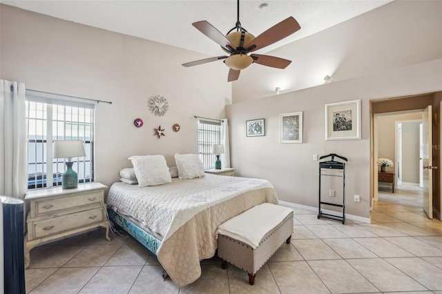 bedroom featuring light tile patterned floors, baseboards, high vaulted ceiling, and a ceiling fan