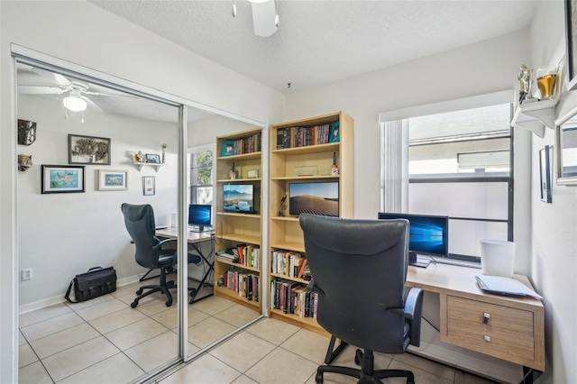 office area featuring a textured ceiling, a ceiling fan, and light tile patterned flooring