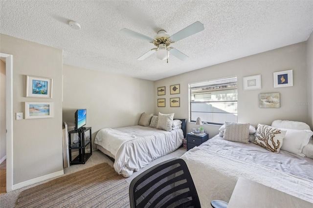 bedroom with ceiling fan, carpet floors, a textured ceiling, and baseboards