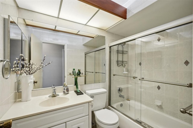 bathroom with enclosed tub / shower combo, toilet, and vanity