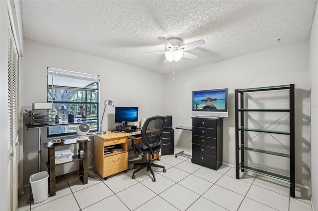 tiled office space with a textured ceiling and a ceiling fan