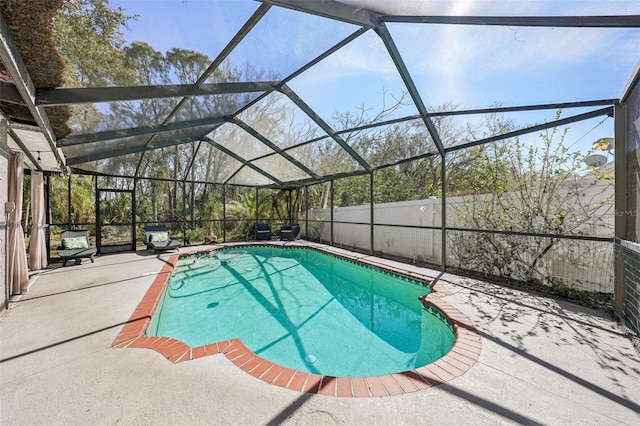 view of swimming pool featuring a fenced in pool, glass enclosure, a patio area, and a fenced backyard