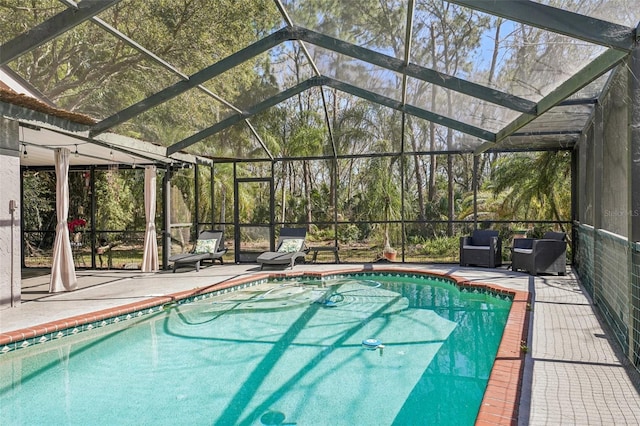 outdoor pool with glass enclosure and a patio area