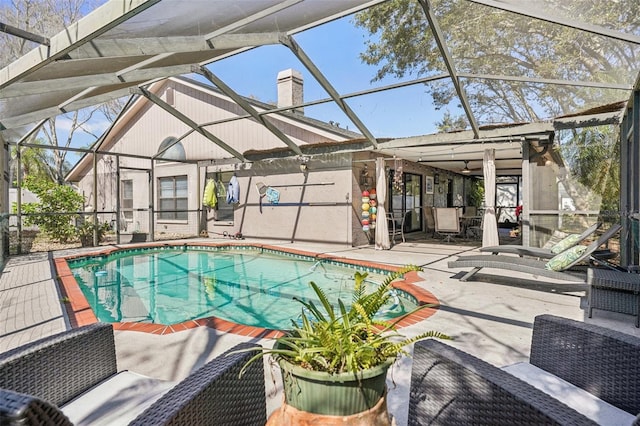 outdoor pool with glass enclosure and a patio