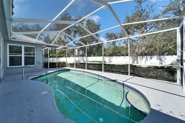 view of pool featuring glass enclosure, a patio area, and fence