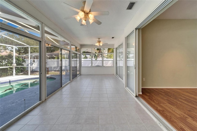 unfurnished sunroom featuring visible vents and ceiling fan