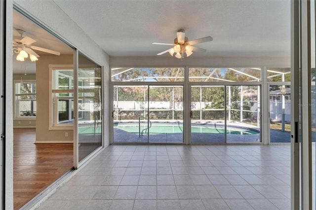 unfurnished sunroom with ceiling fan