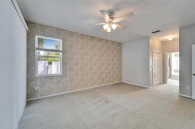 unfurnished room featuring visible vents, light carpet, and baseboards