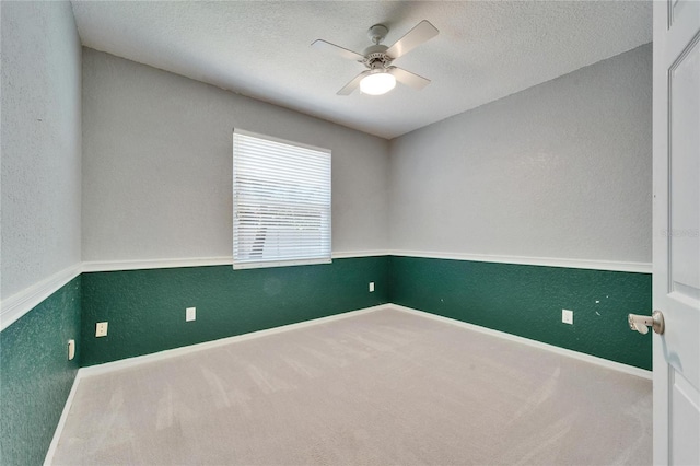 spare room with baseboards, a textured wall, ceiling fan, a textured ceiling, and carpet floors