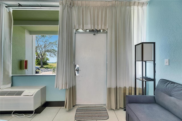 doorway with a wall mounted AC and tile patterned floors