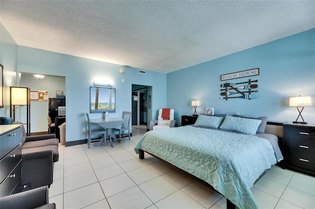 bedroom with light tile patterned floors, a textured ceiling, and visible vents