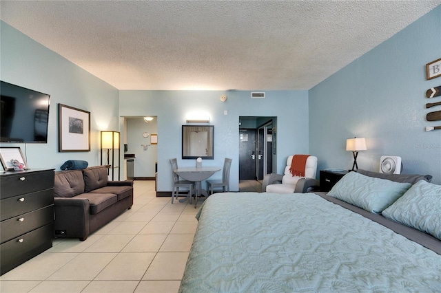 bedroom with visible vents, a textured ceiling, and light tile patterned floors