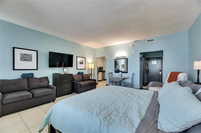 bedroom with refrigerator, visible vents, a textured ceiling, and light tile patterned flooring