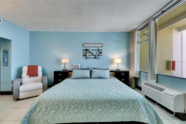 bedroom with a textured ceiling, a wall unit AC, and tile patterned flooring